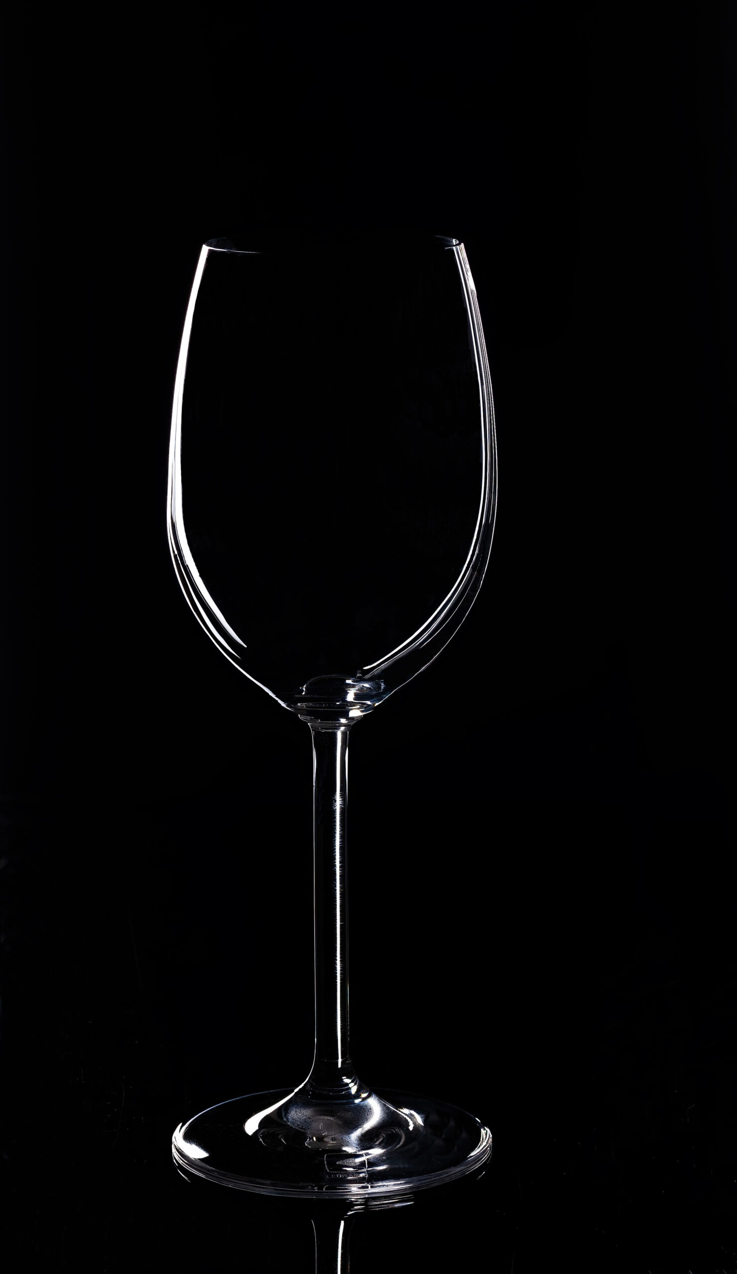 Foto von einem Weinglas vor einem schwarzen Hintergrund.